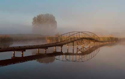 Houten brug in de mist in het Zeeuwse landschap